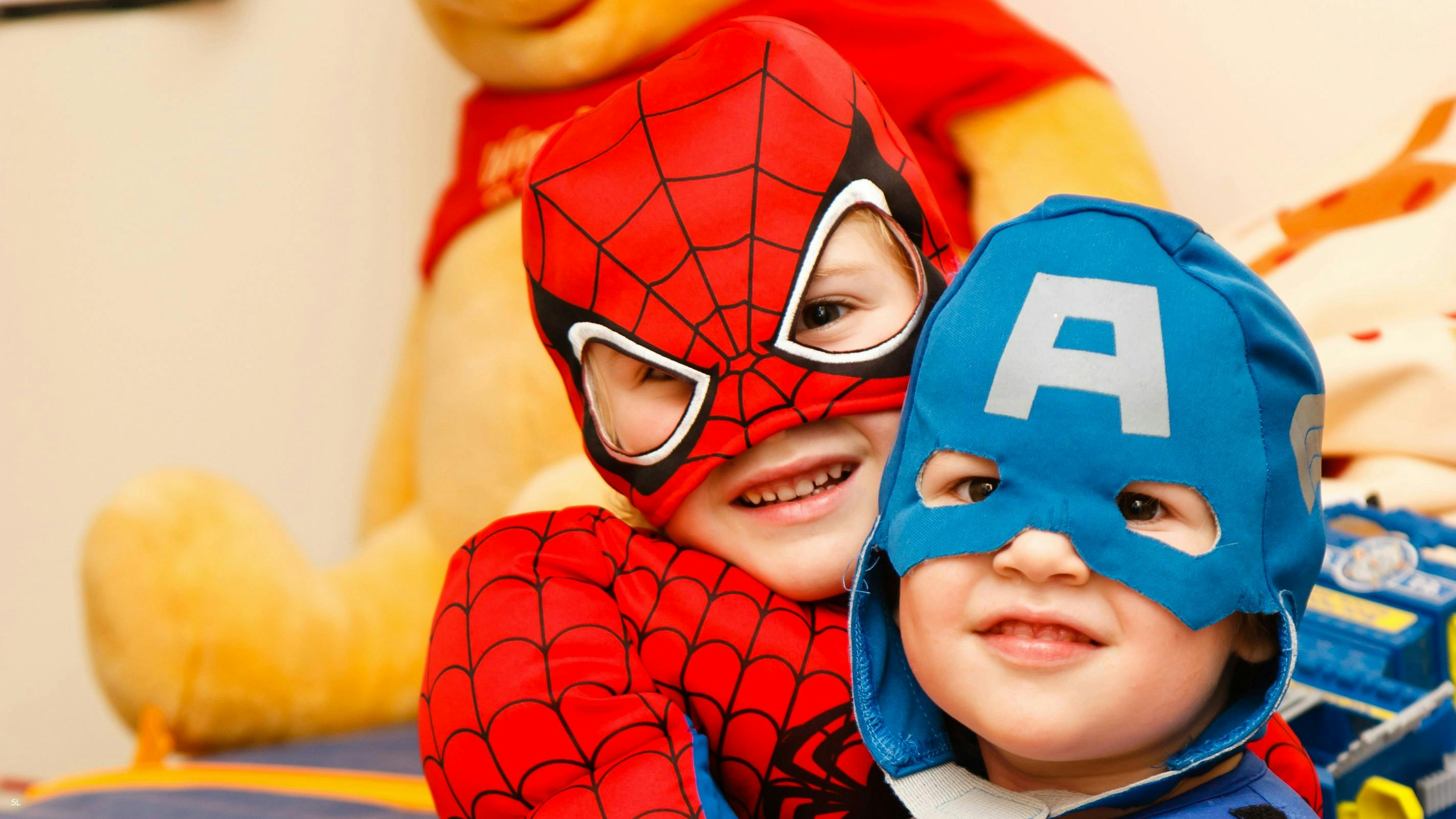 Two young children dressed as super heroes.