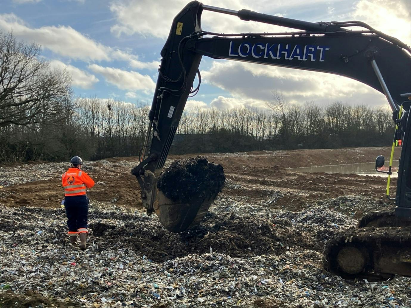 excavator digging pit for waste sampling