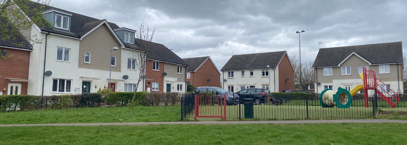 A playground in front of a group of houses