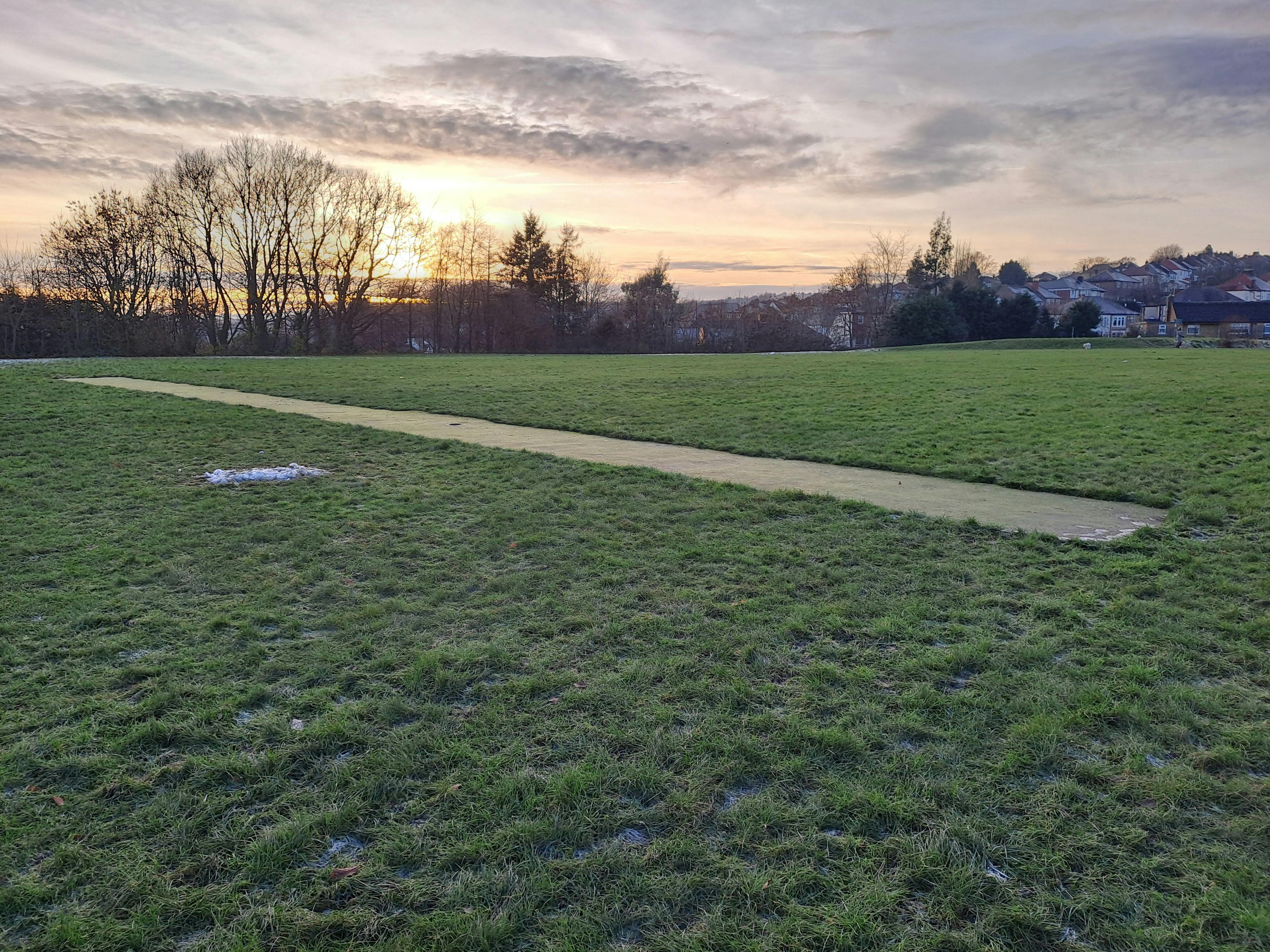 Cricket wicket in between the grass football pitches