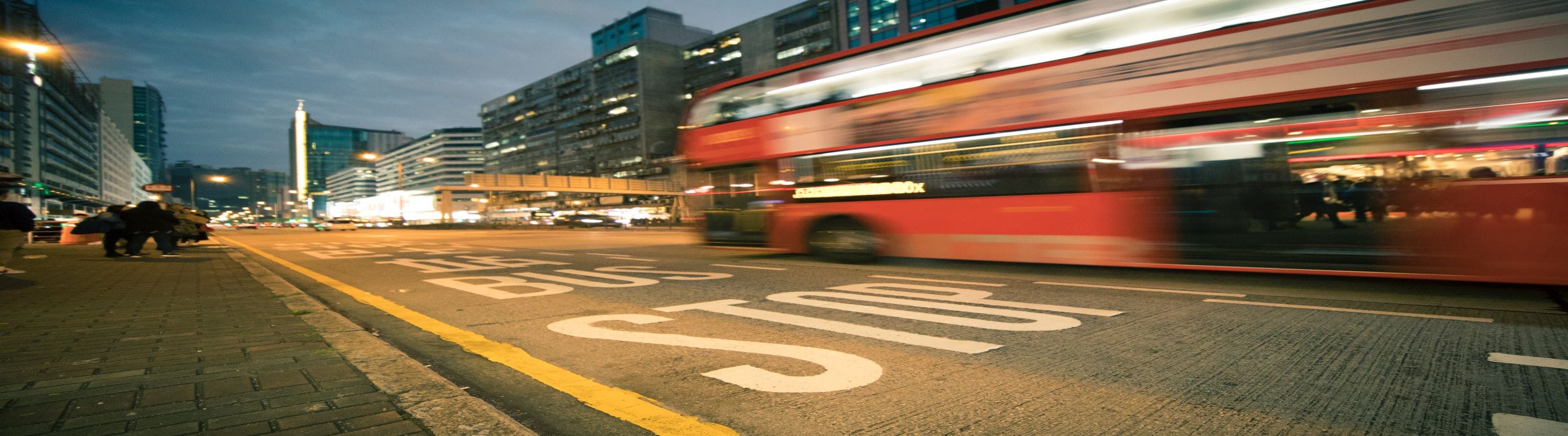 Photo of bus stop and red double decker bus.