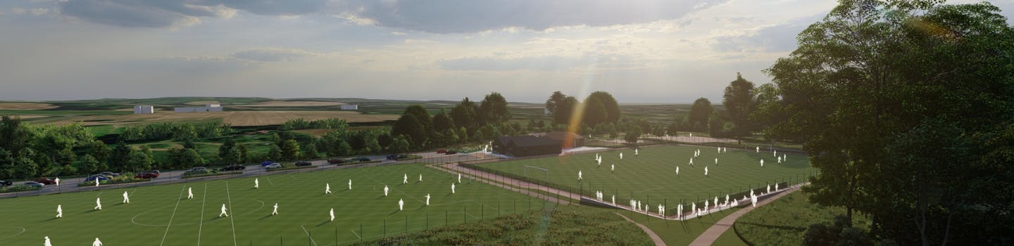 Picture shows people playing on football pitches with landscape in the background