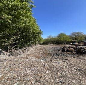Early May 2026 progress on waste clearance: note wooden fencing on site boundary is now visible