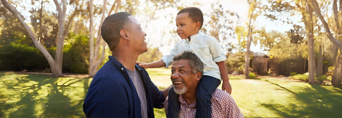 A grandfather with son and grandson having fun in a park 