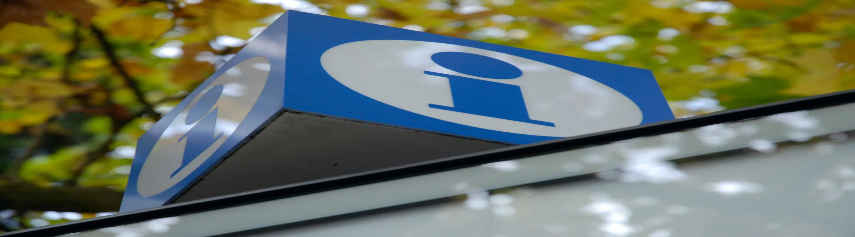 Photo of white & blue "I" information logo on top of structure.