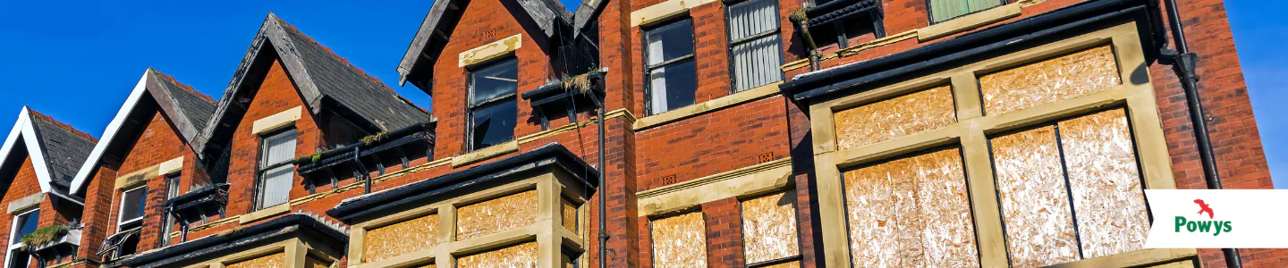 A row of derelict houses with the windows boarded up