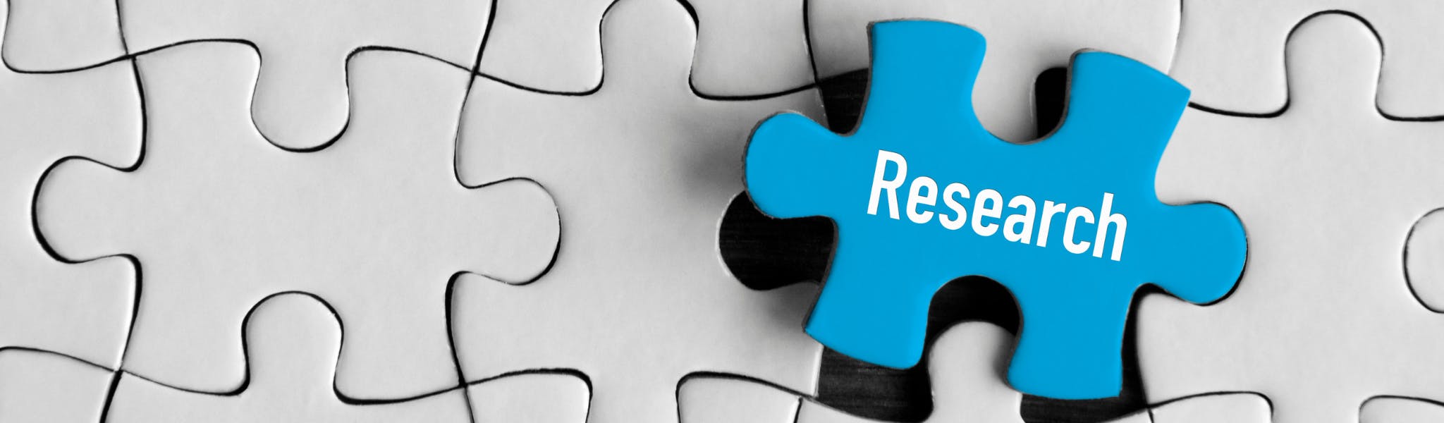 An image of a blue jigsaw piece with the word research on it