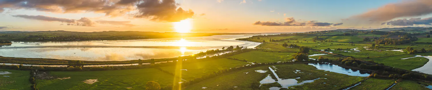 Sunset across the estuary overlooking fields, wetlands and the trainline at Exminster.
