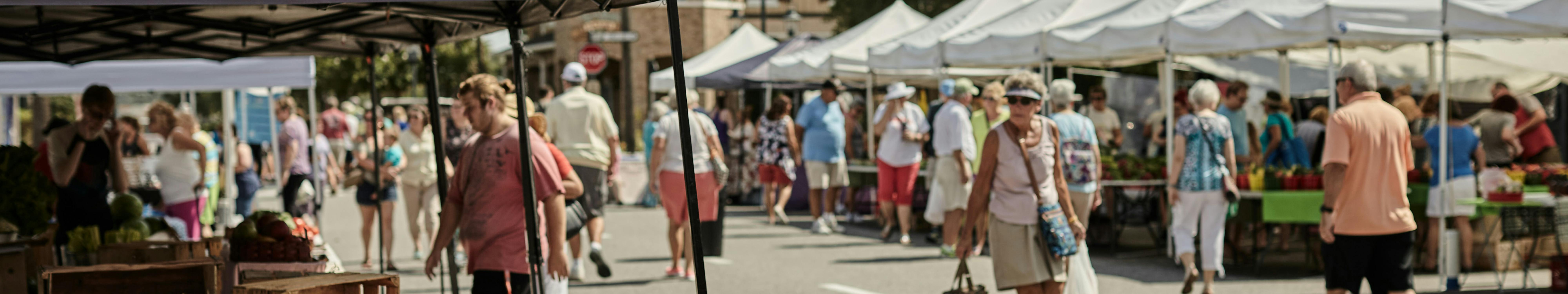 outdoor market stalls with lots of people wandering around