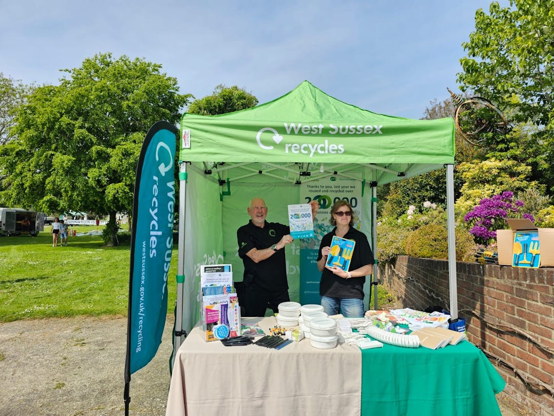 Two Waste Prevention Volunteers (one male one female) managing a stand during an outdoor event