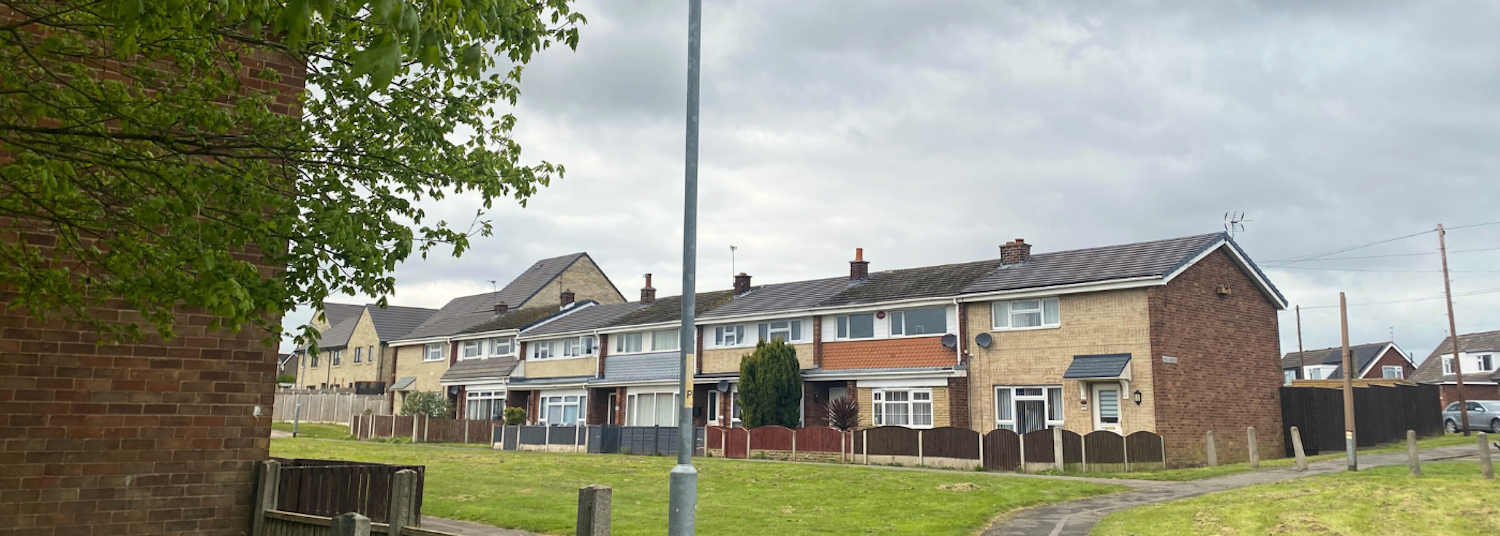 A row of terraced houses with grass in front of them