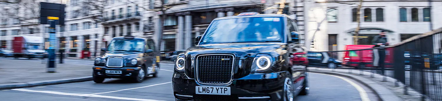 Two taxis travelling on a central London road
