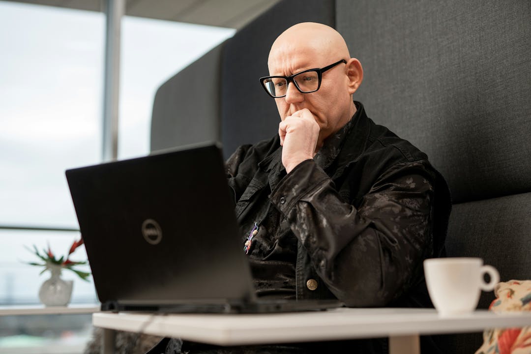 Male adult filling in an online questionnaire using his laptop