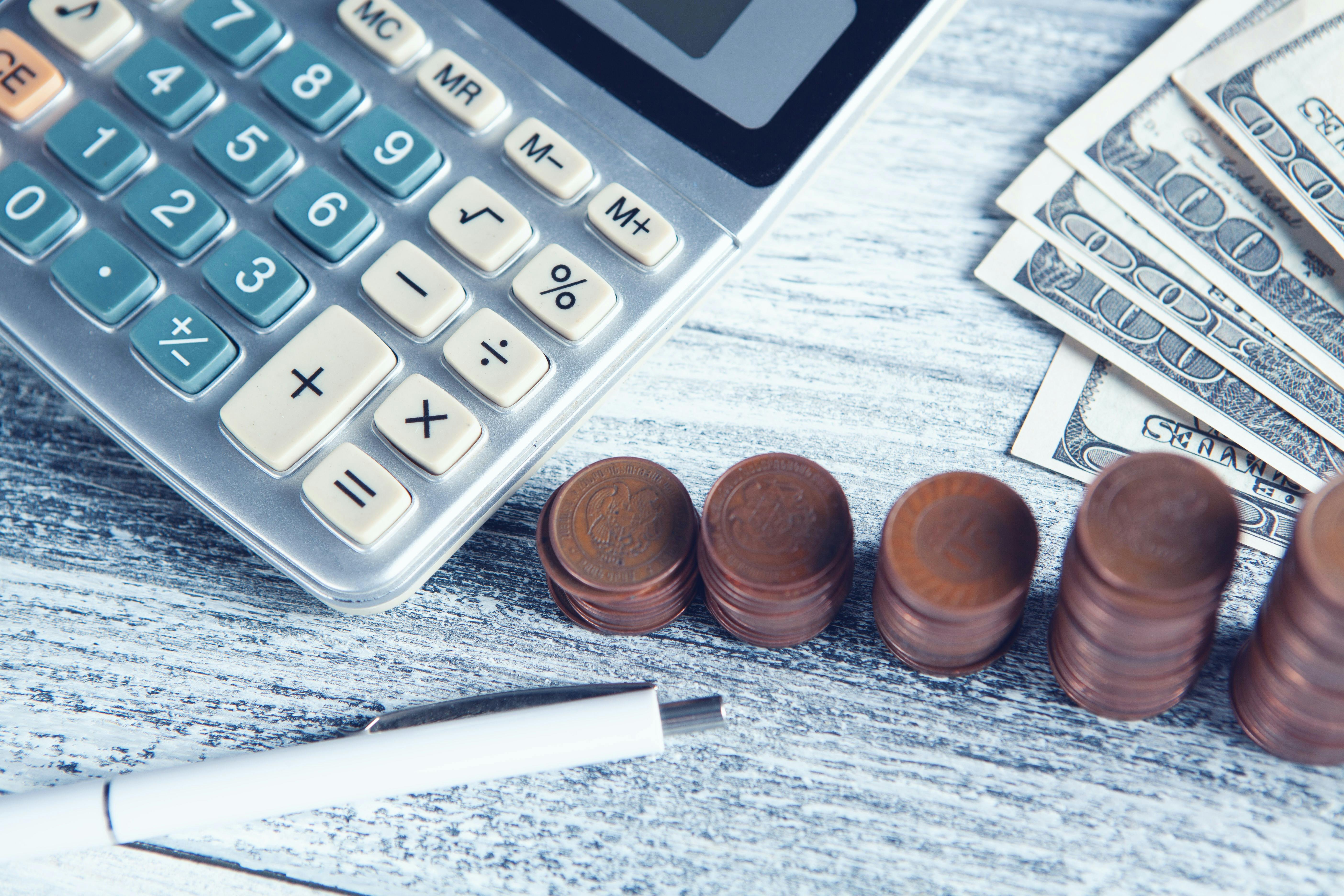 calculator, coins and a pen