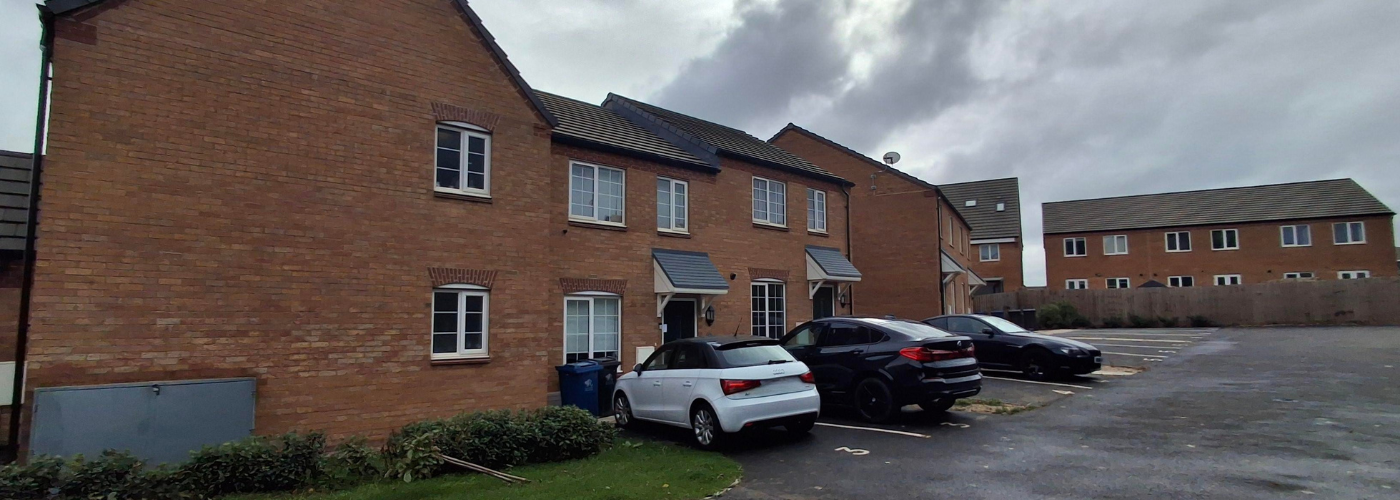 A street of houses with cards parked in front.
