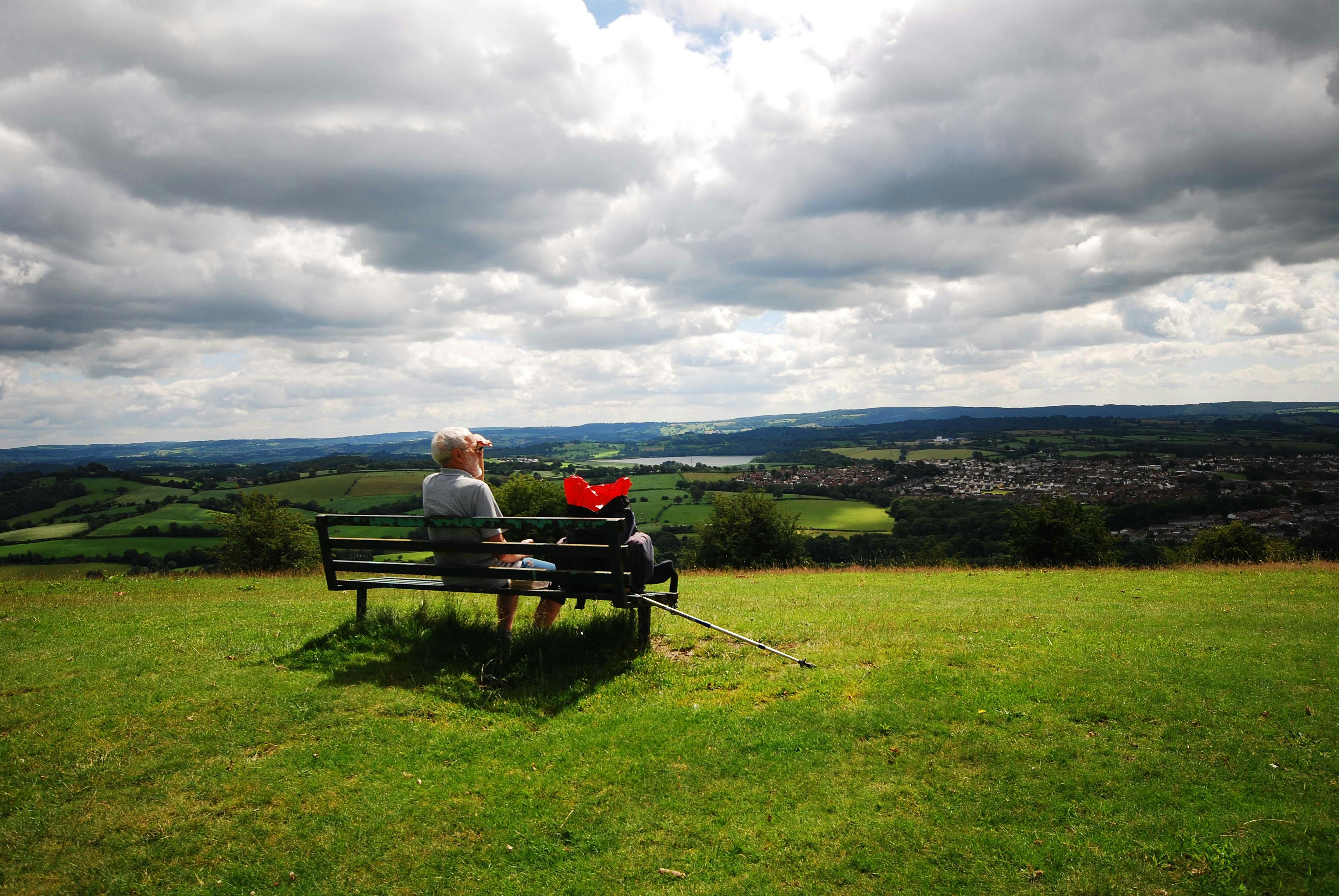 Gentleman sat on a bench looking out across Torfaen's landscape 