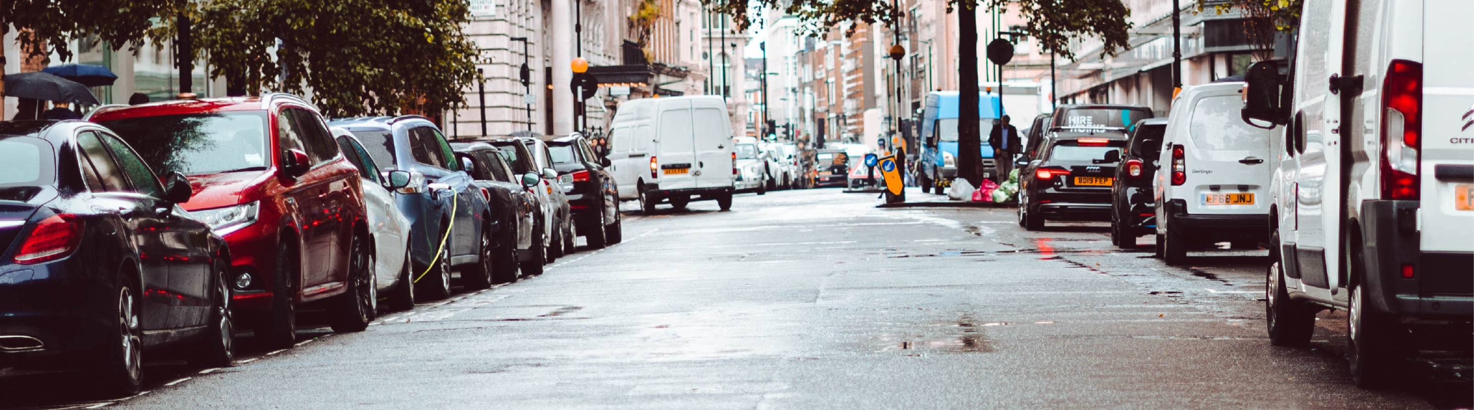 Photo of cars parked on both sides of a road.
