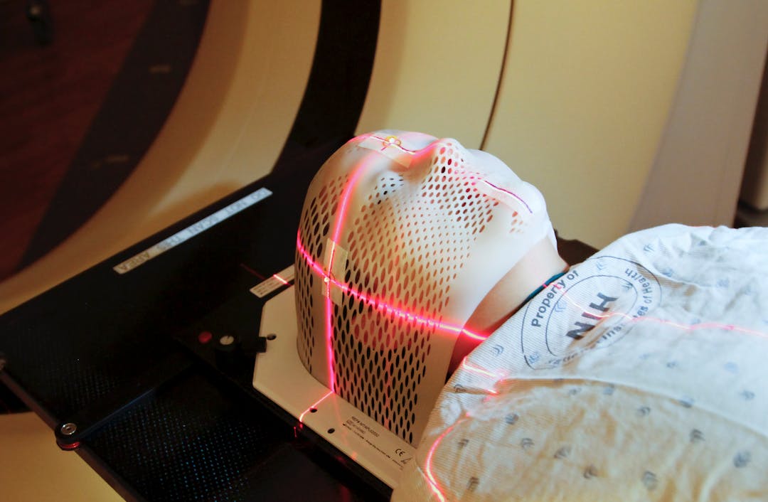 Lasers are used to position a patient model wearing a short face mask in a computed tomography (CT) scanner to obtain images of a tumor before radiation therapy 