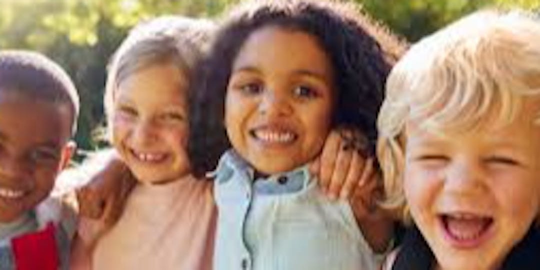 Image of four children arm in arm and laughing together