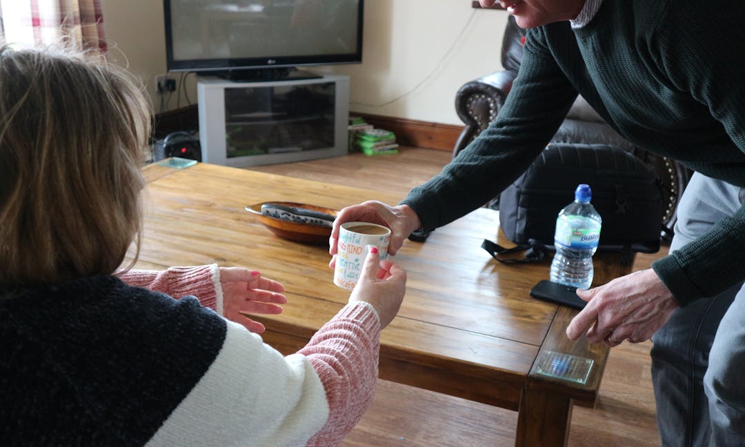 A person being given a cup of tea