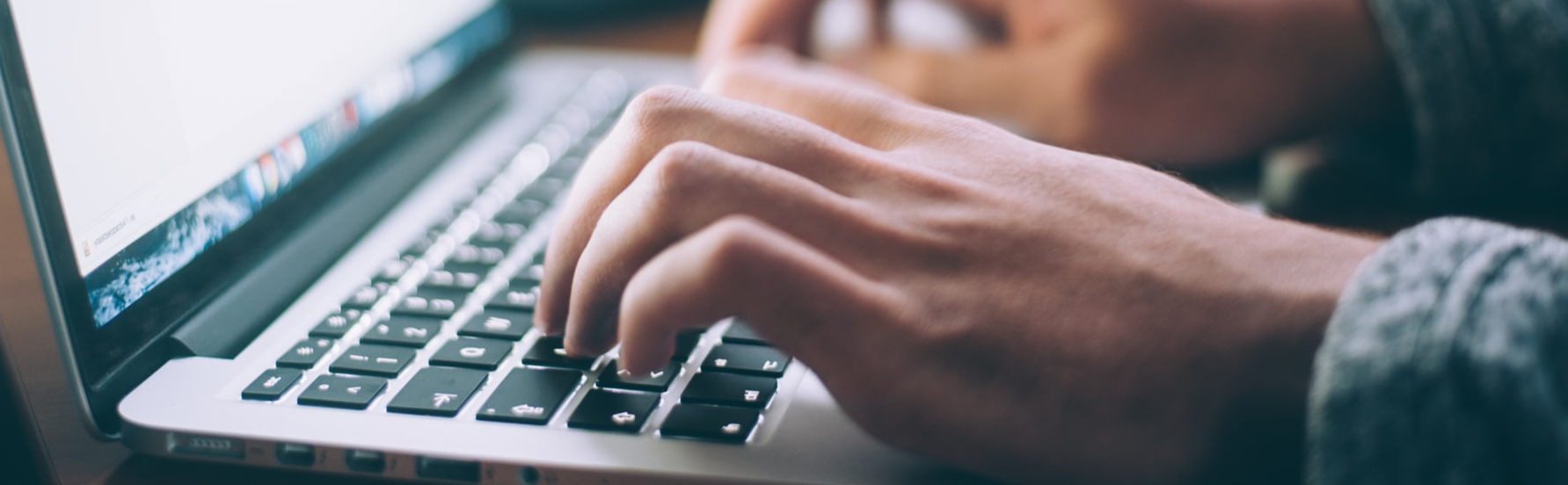 Fingers typing on laptop