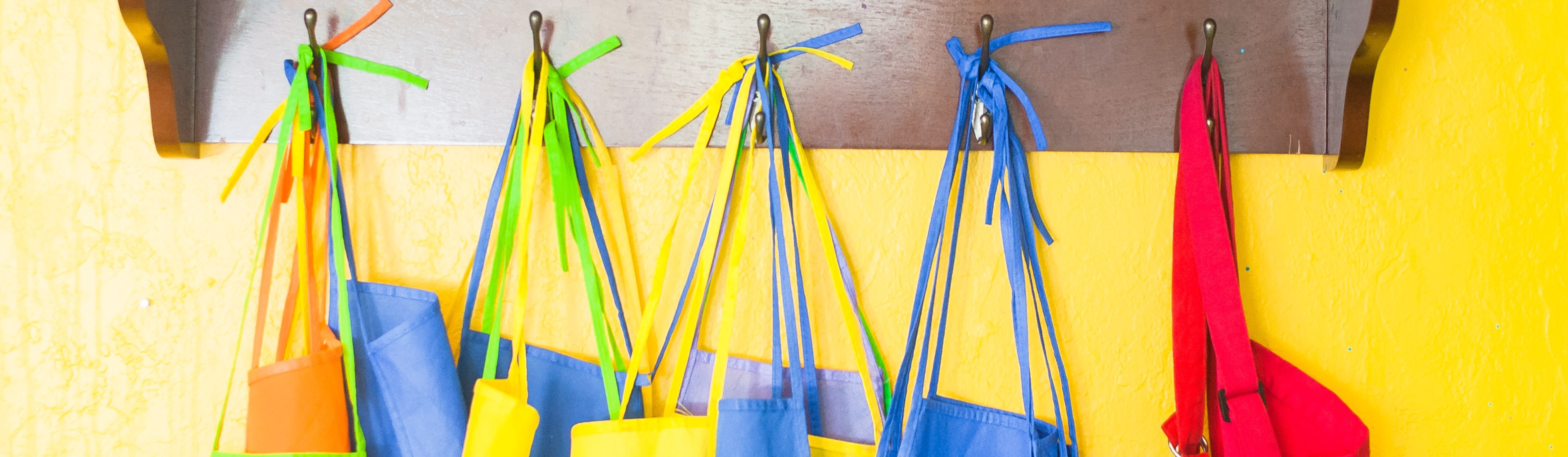 Multicoloured aprons hung on hooks
