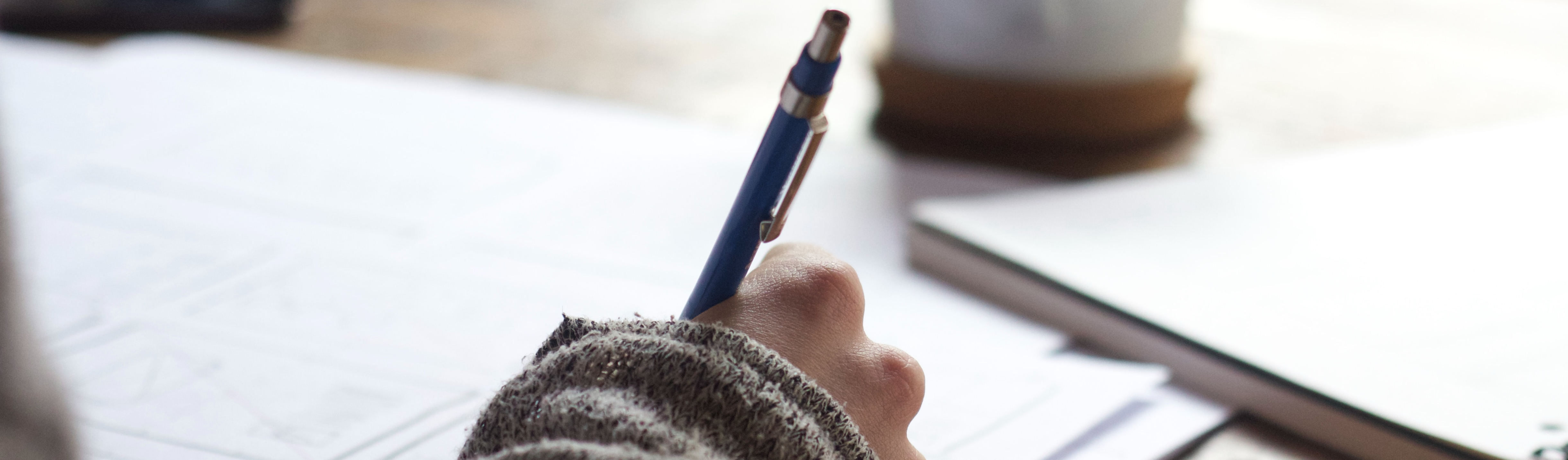 Hand holding a pen to write