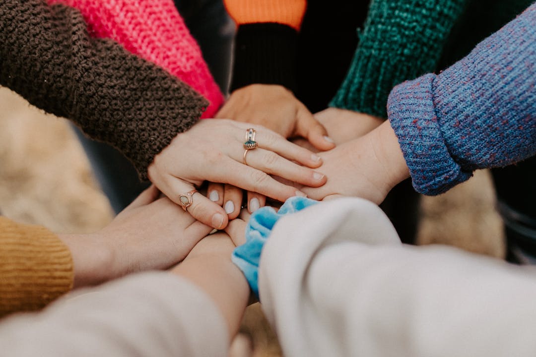 People holding hands in centre of circle. Image by Hannah Busing