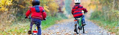 Children learning to ride their bikes in a park