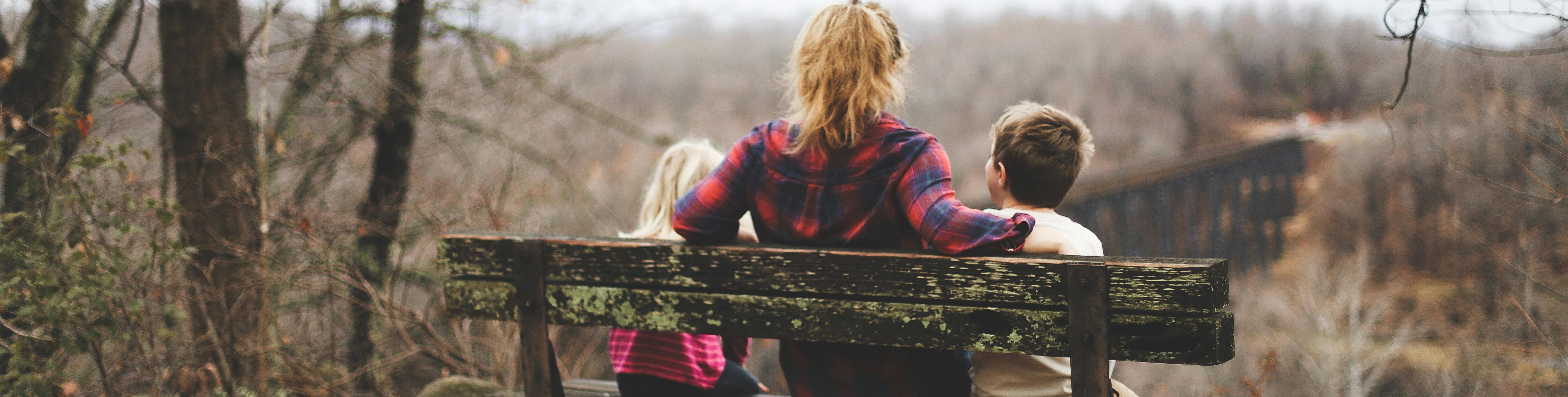 Family sitting on a bench with backs to camera