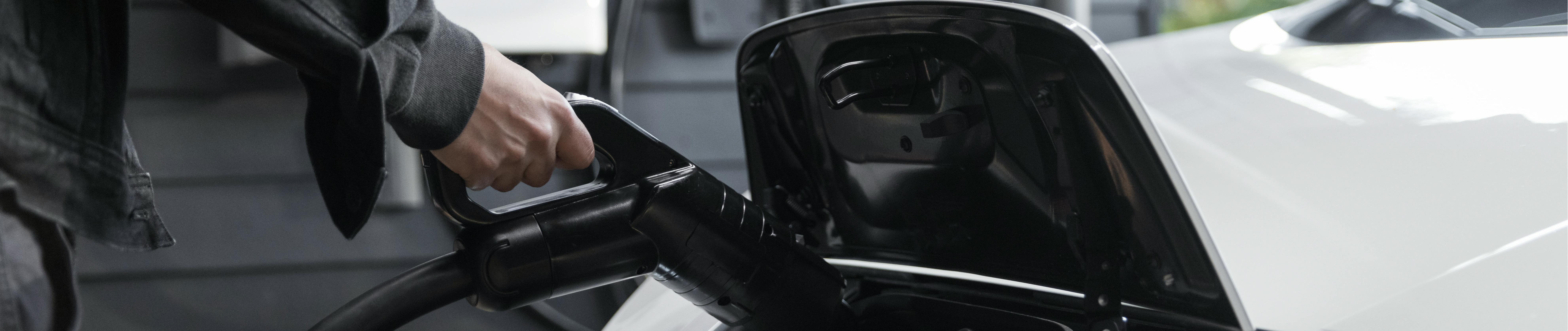 Person charging an electric vehicle at home