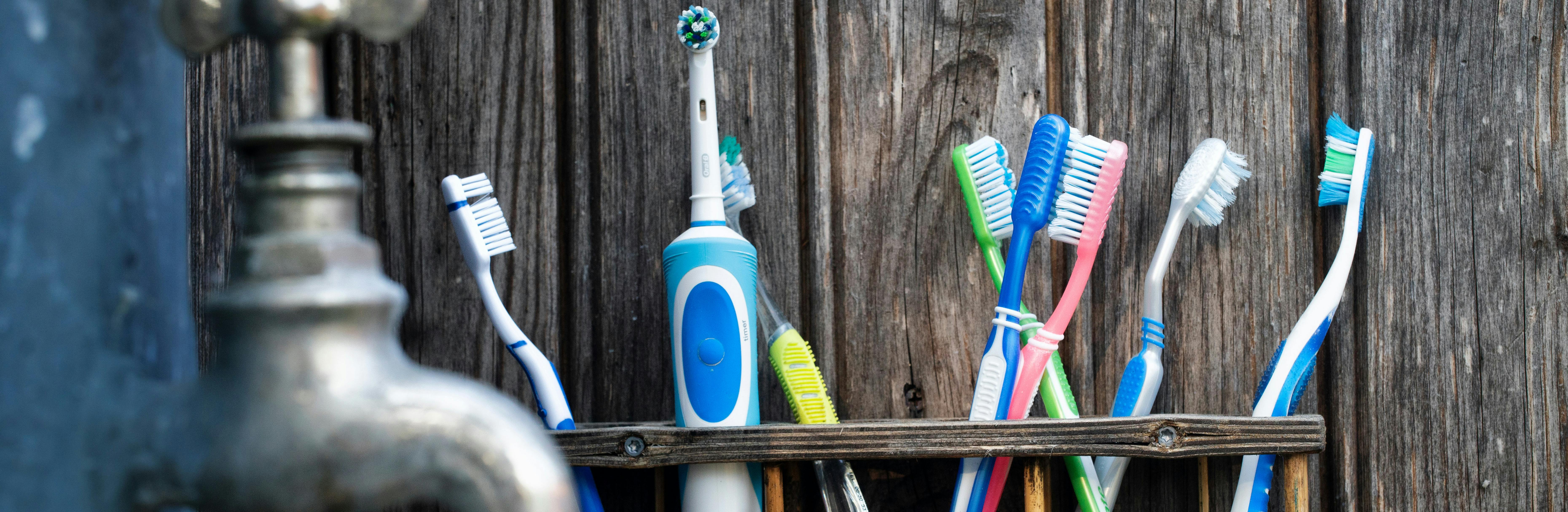 Tap and toothbrushes on a shelf