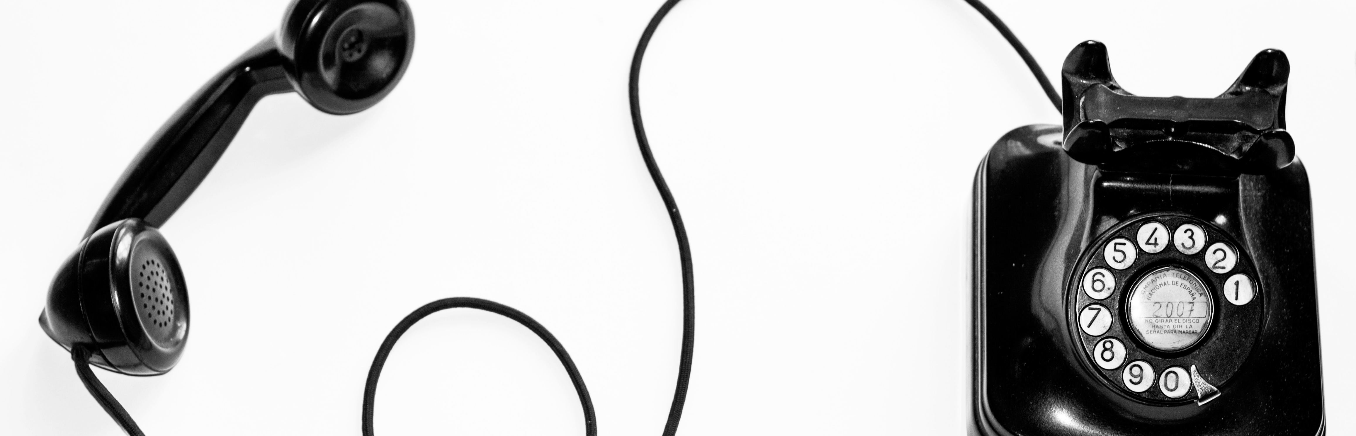 An old fashioned spin-dial telephone on a white background