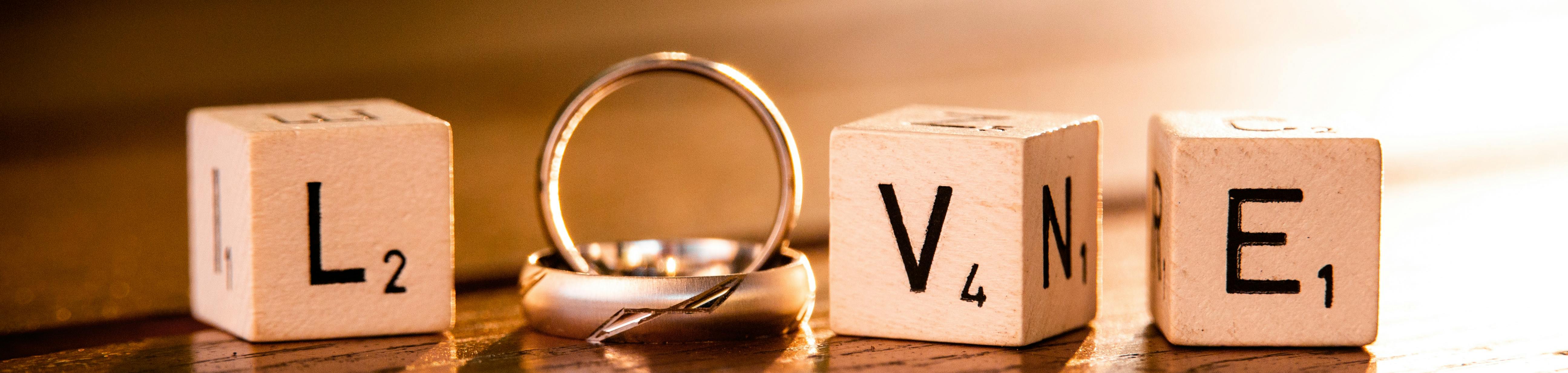 Wooden cube spelling love with wedding rings as the 'o' in love