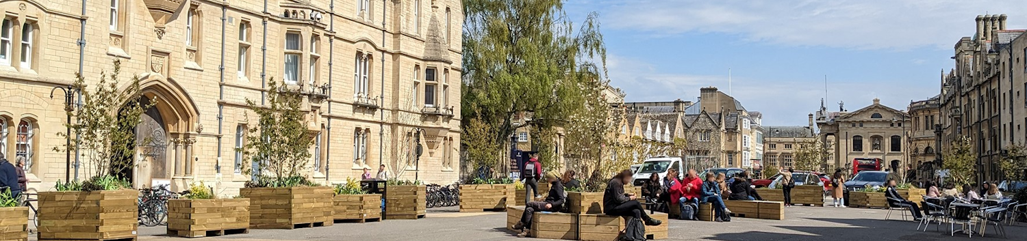 Photograph of Broad Street, Oxford with benches and planters full of plants
