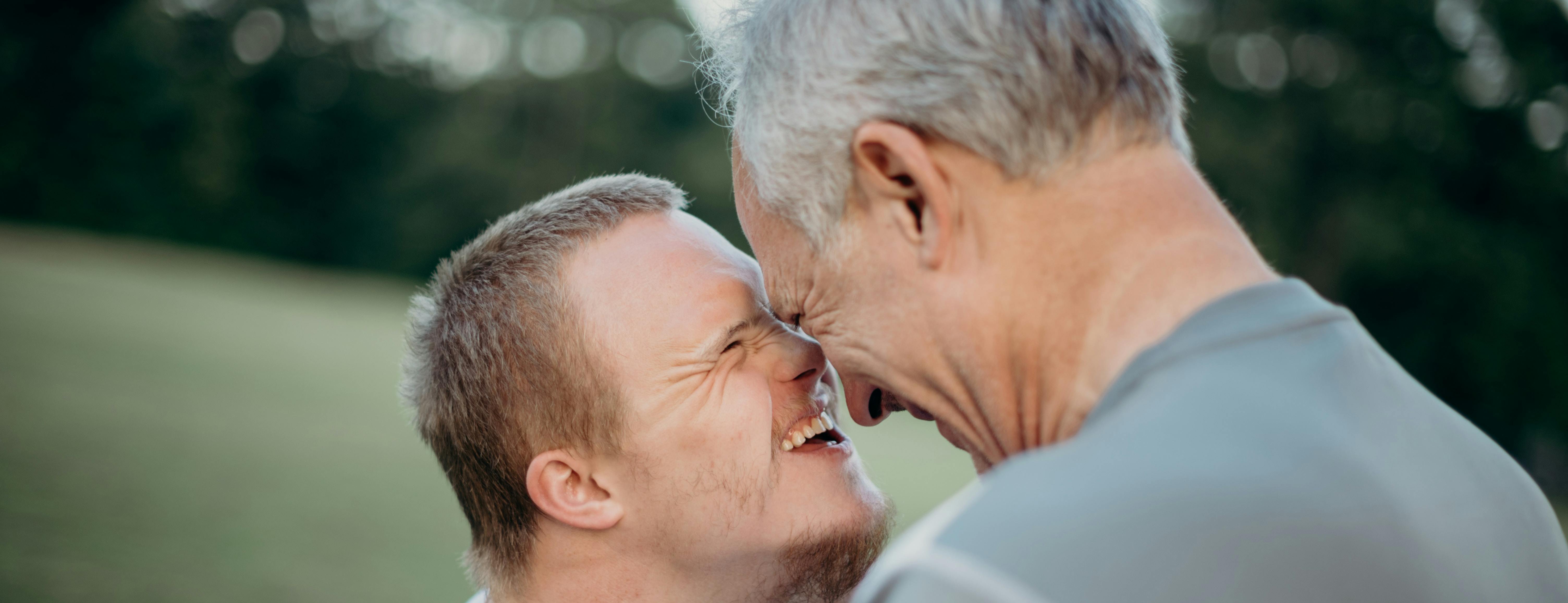 Person with learning disabilities and older person bumping heads