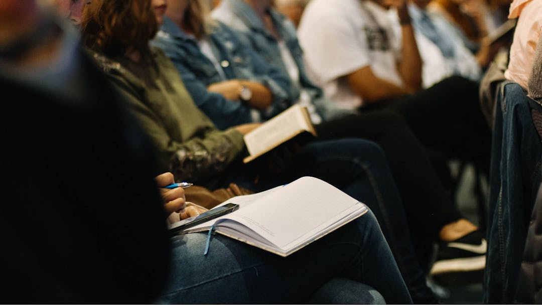 Image of people sitting with books on their laps in an informal learning environment