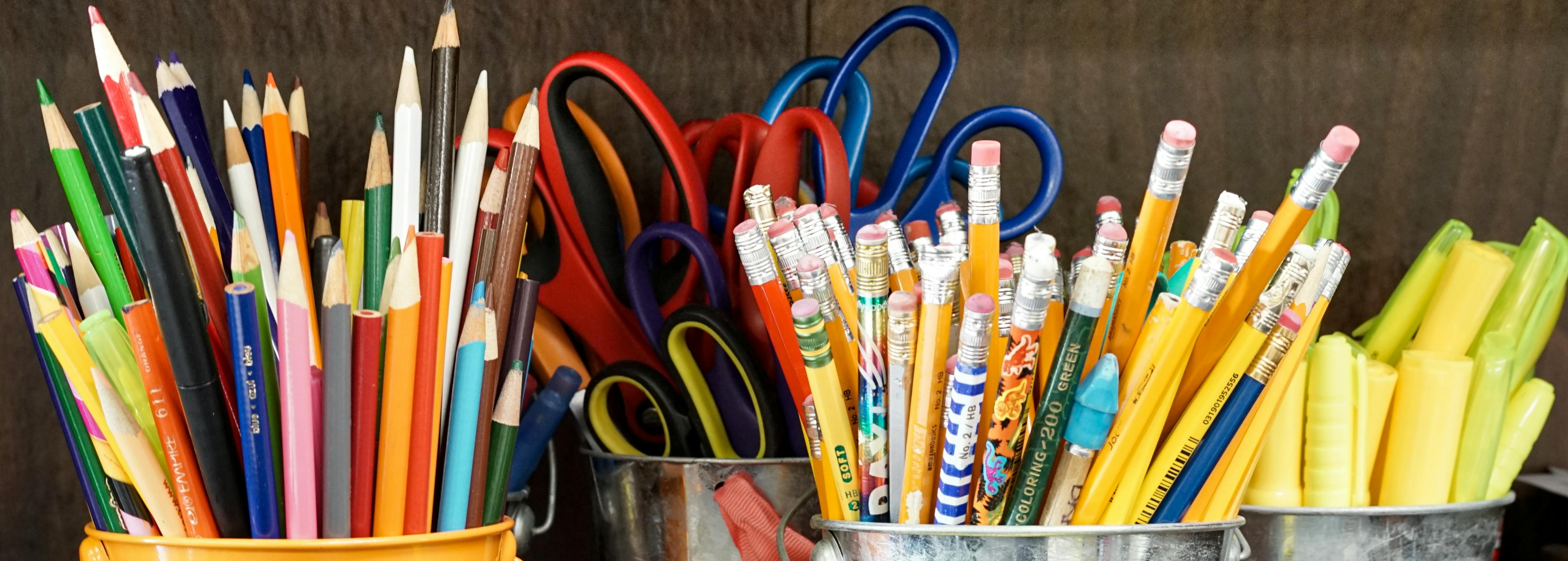 Multicoloured pencils and pens in pots