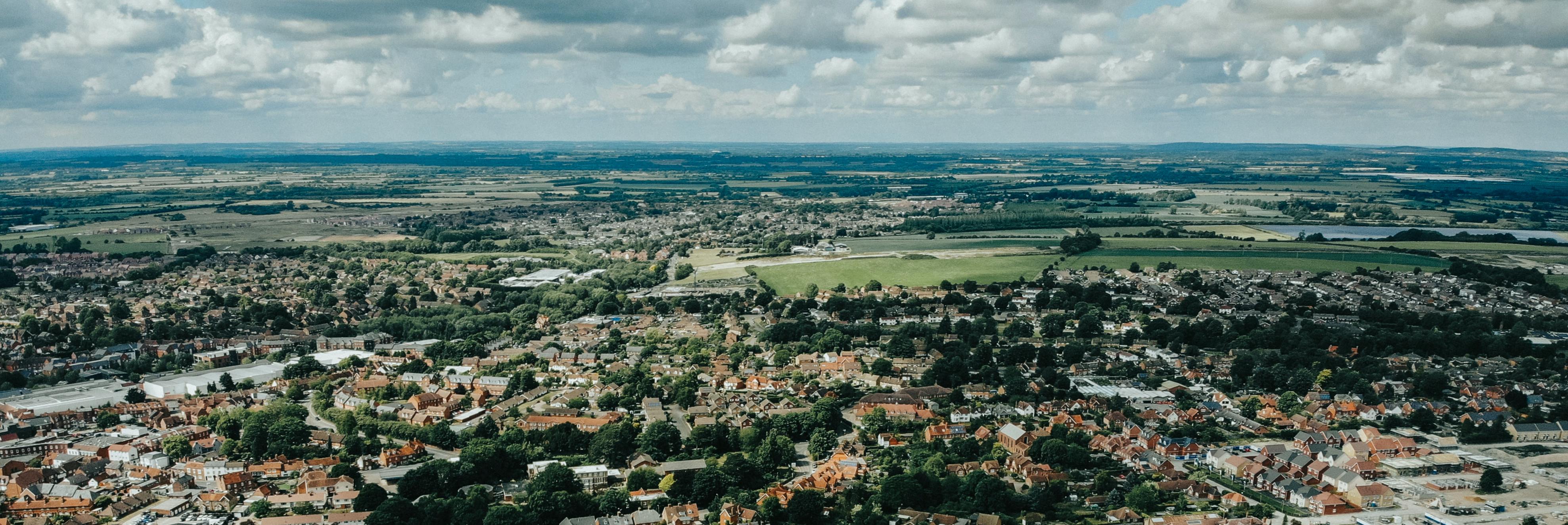 An aerial view over an Oxfordshire town with countryside behind it