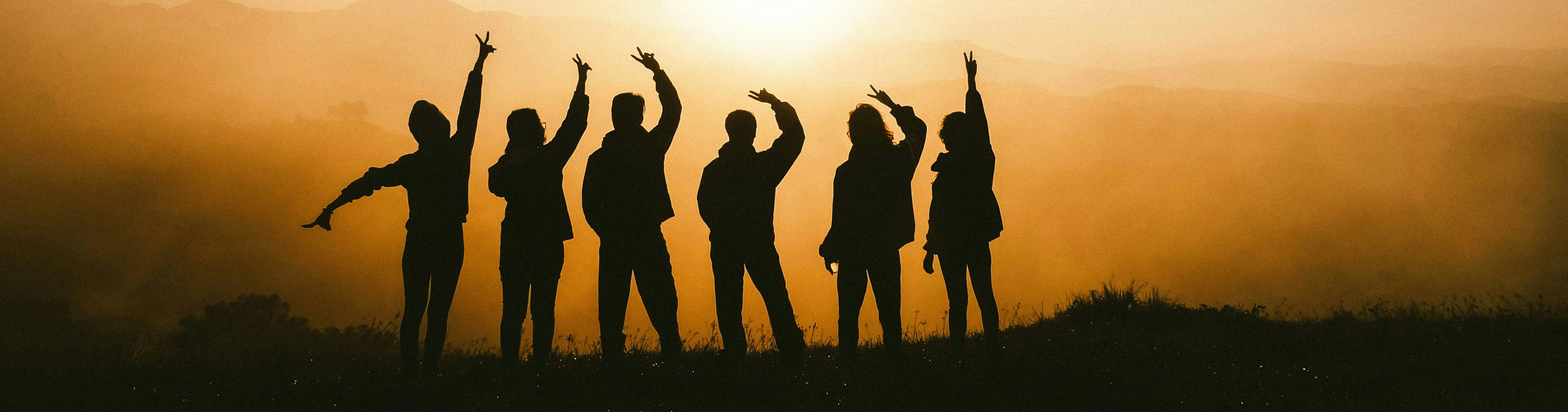 Shadows of young people against a sunset