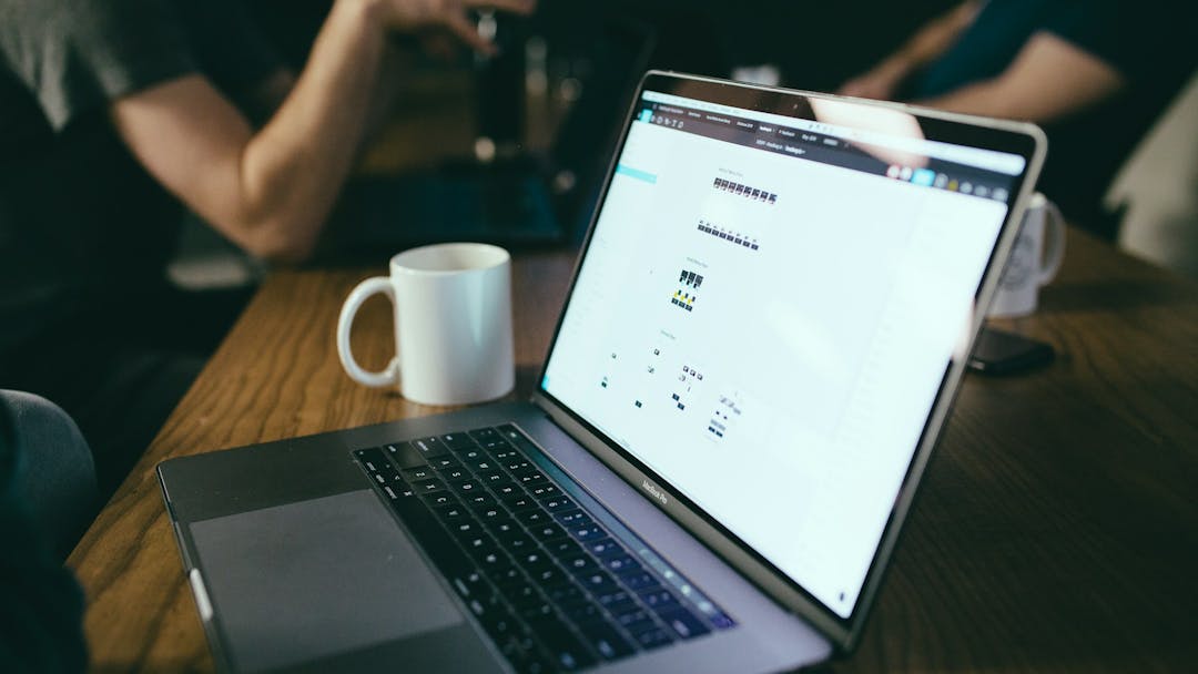 Coffee cup next to laptop computer