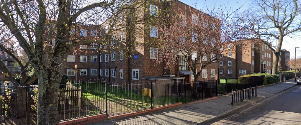 Peregrine House block of flats with trees either side. 