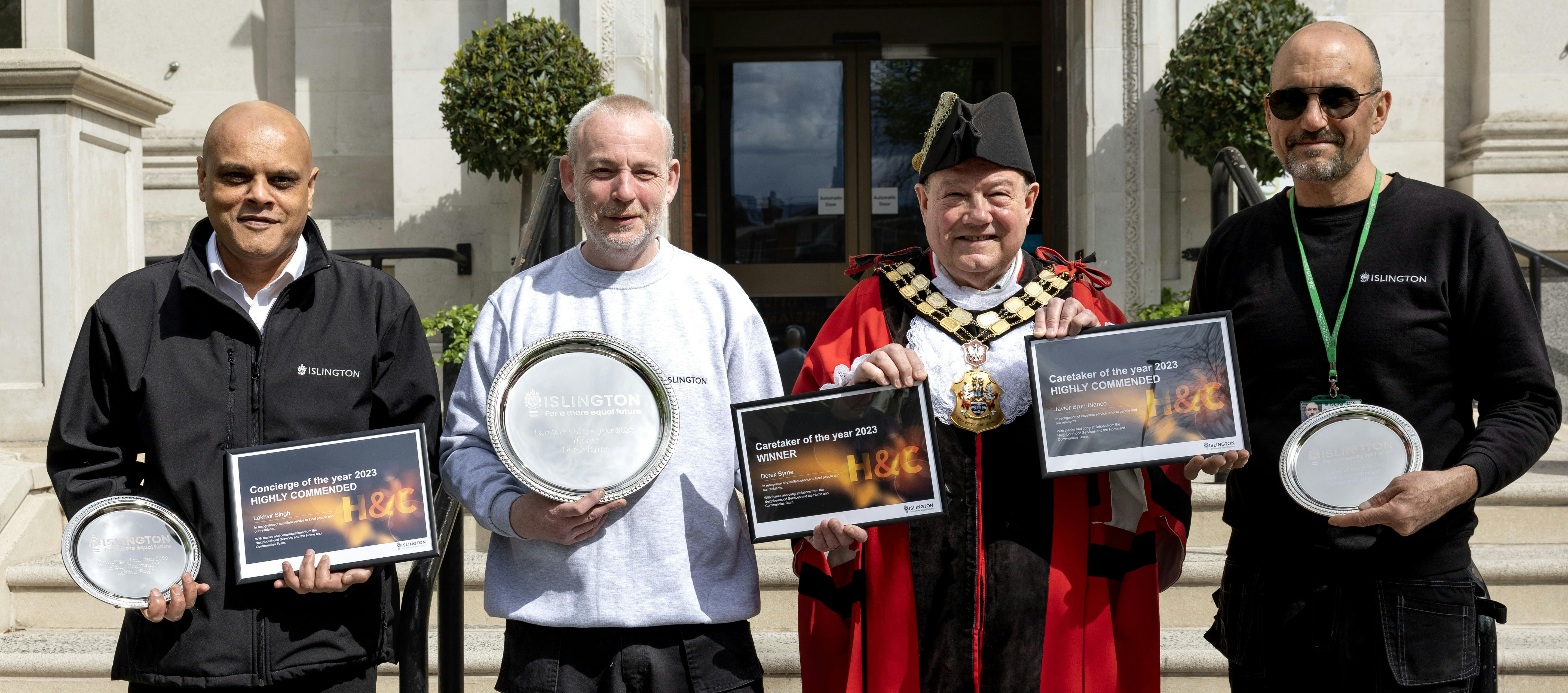 Group of people smiling at the viewer and holding awards