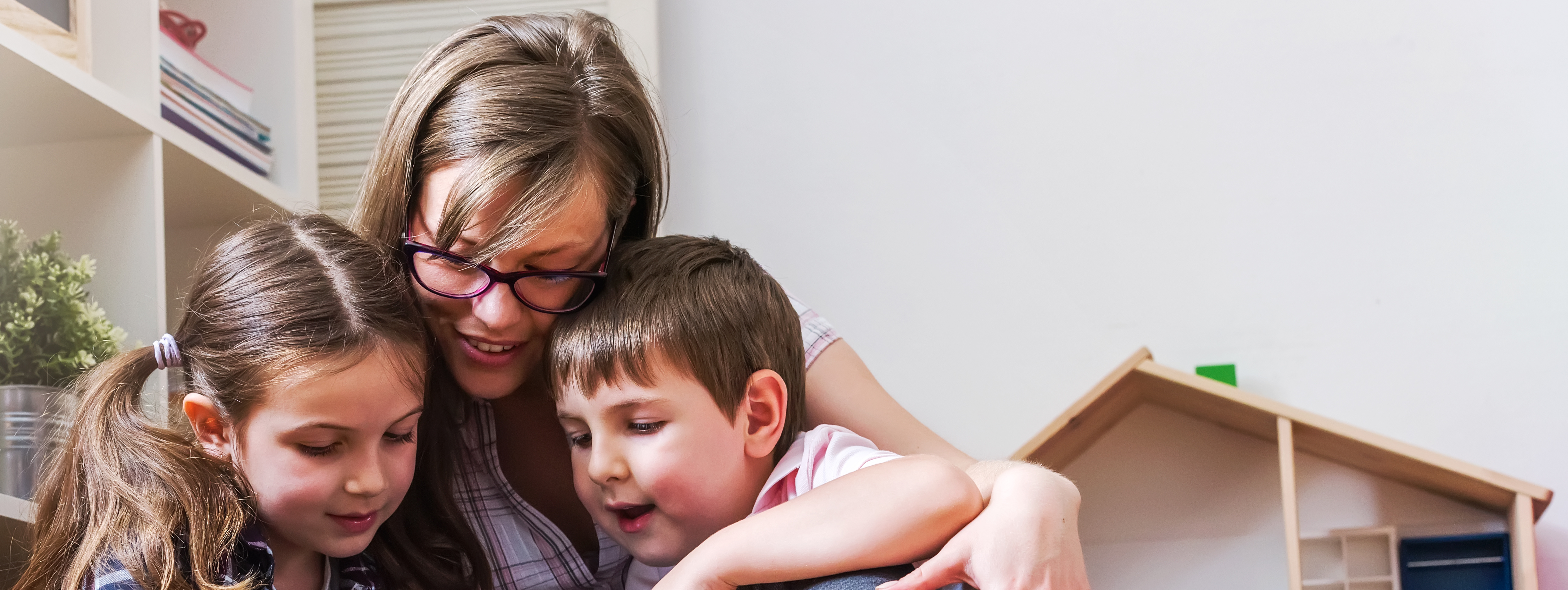 Parent and two children looking at ipad