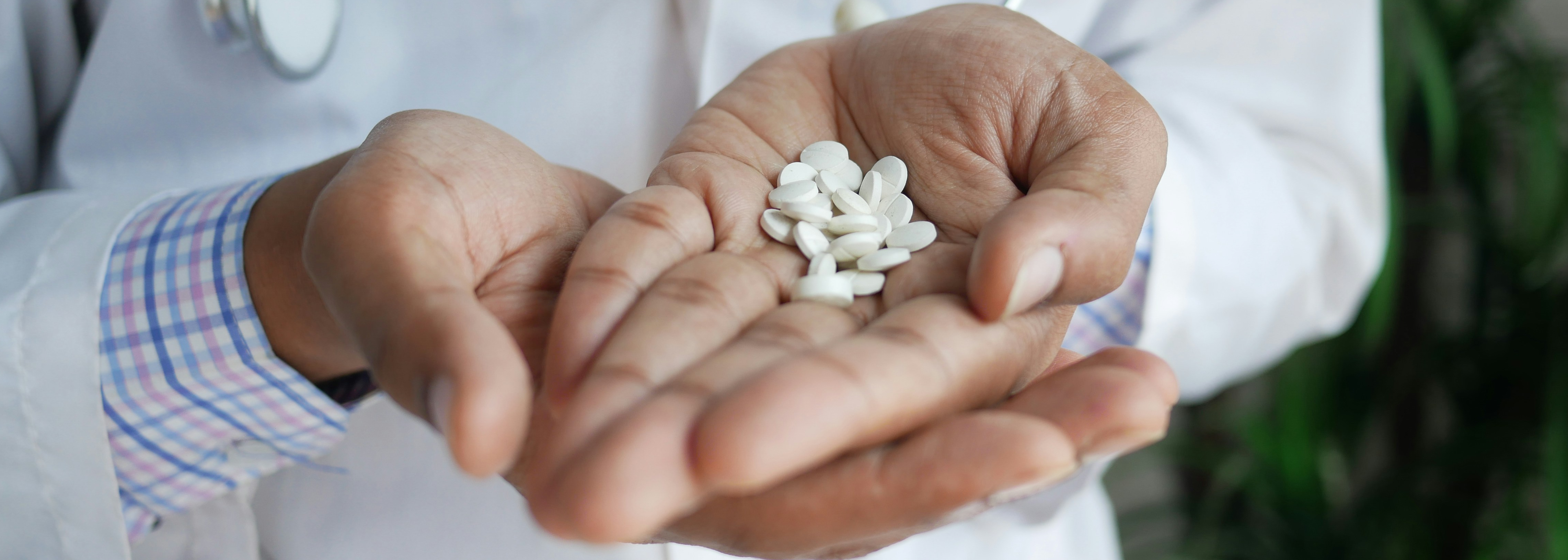 Doctor holding white pills in his hands