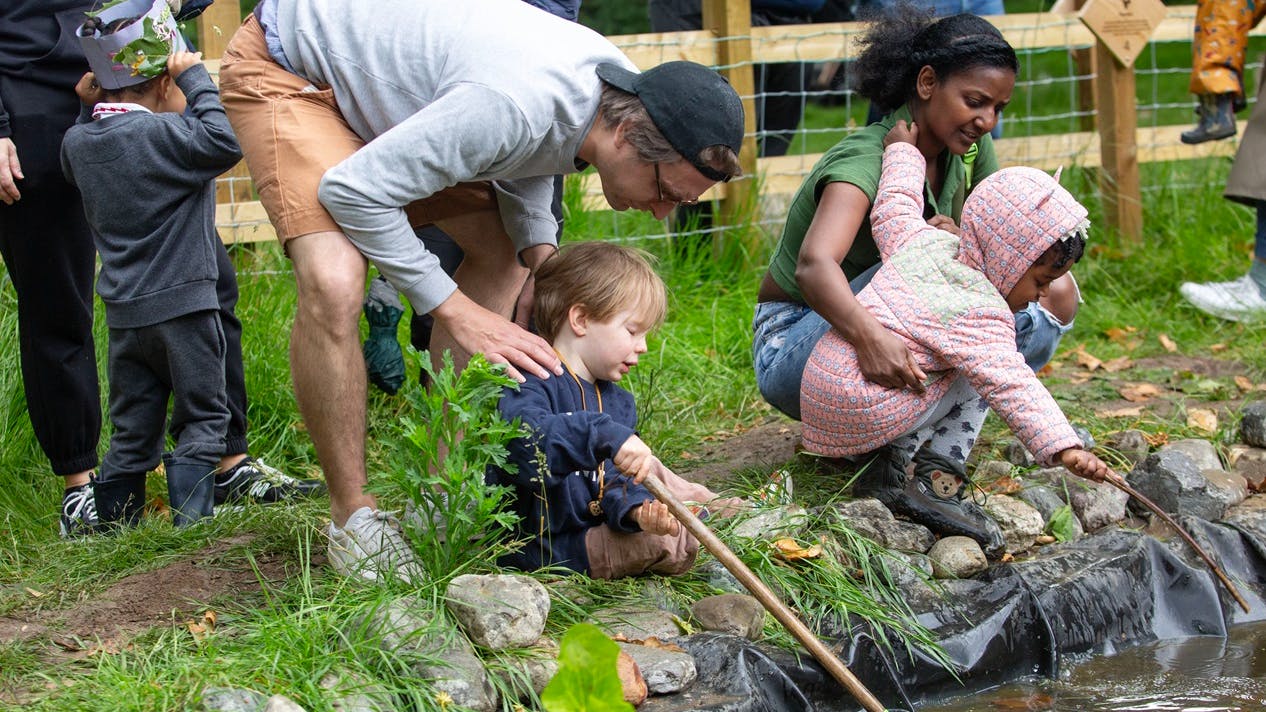 Parents with young children pond fishing