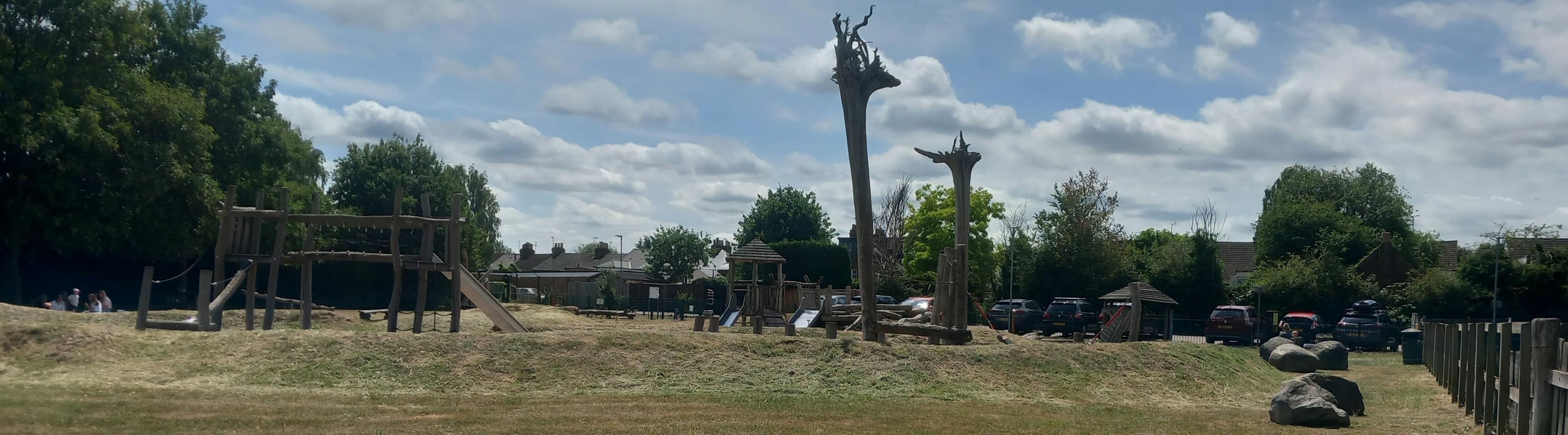 Play area on a sunny day with a variety of wooden play equipment