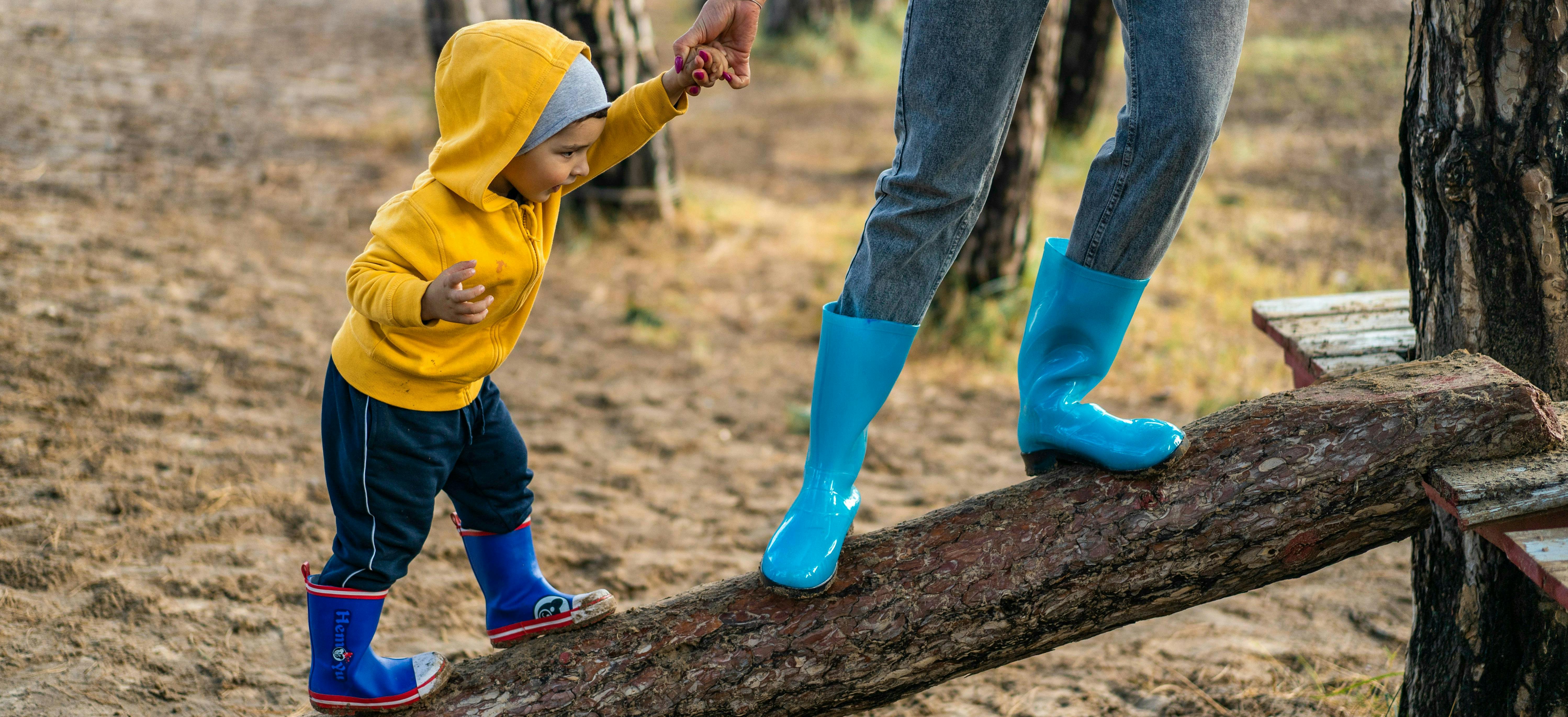 Young boy balancing with support from adult