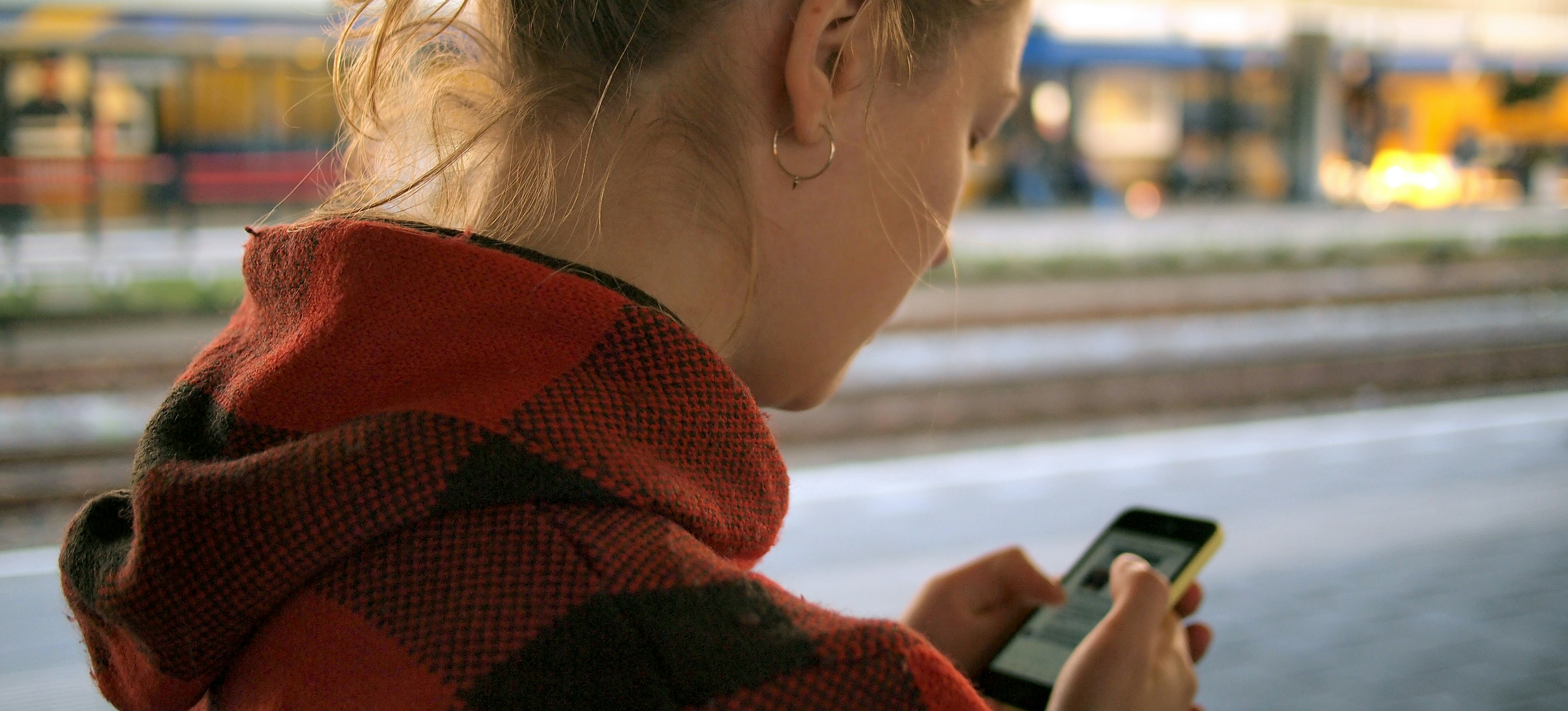 Woman using a mobile phone while standing on the street 