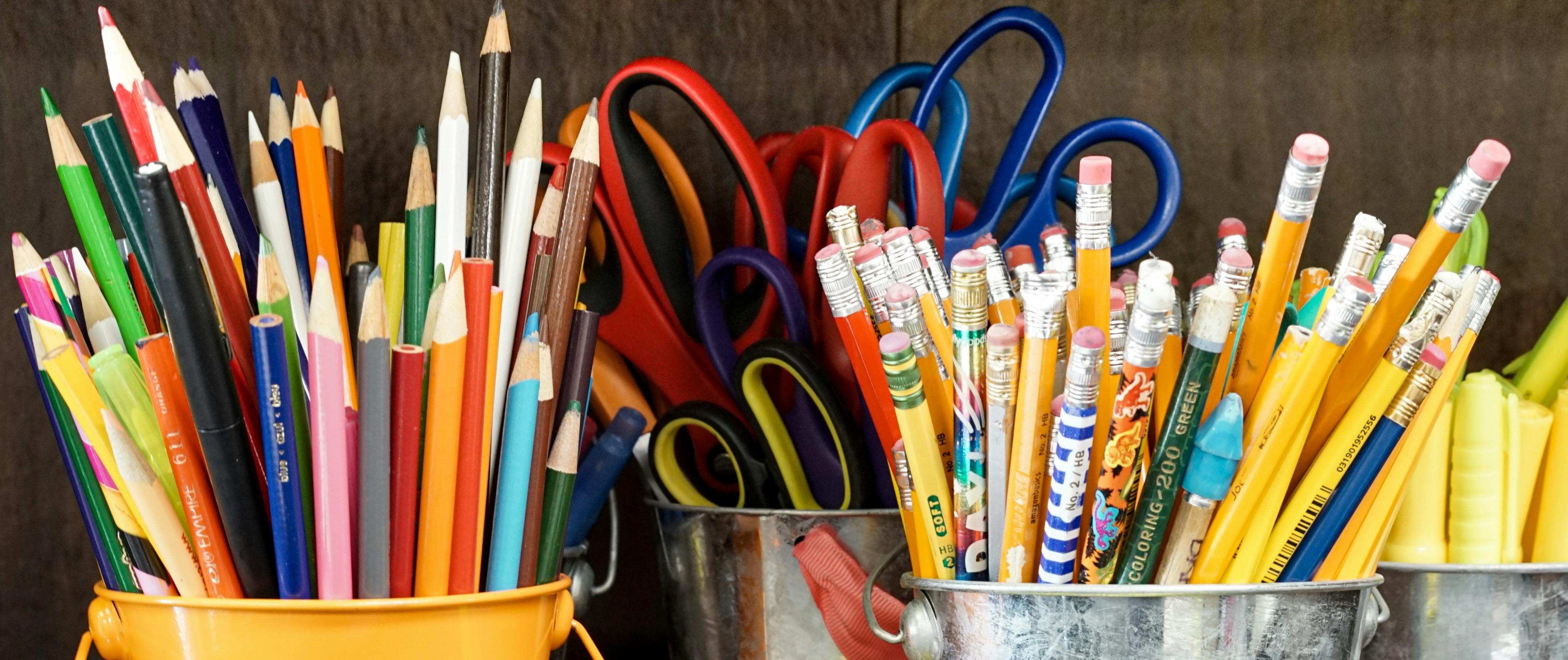 Coloured pencils and scissors in paint pots